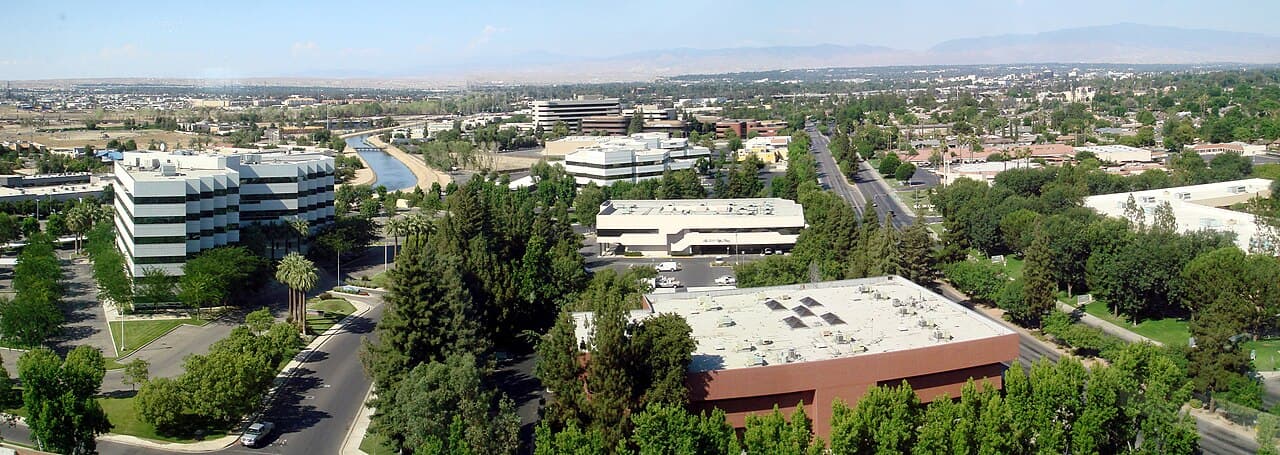 Bakersfield office buildings and California Avenue seen from Stockdale Tower, with mountains beyond the city.