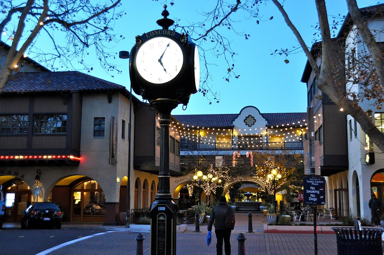 The Concord clock and buildings beside Todos Santos Plaza at dusk.
