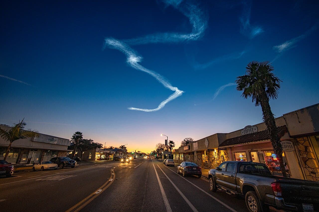 Hollister Avenue storefronts in Old Town Goleta at dawn, with a rocket trail remaining in the sky.