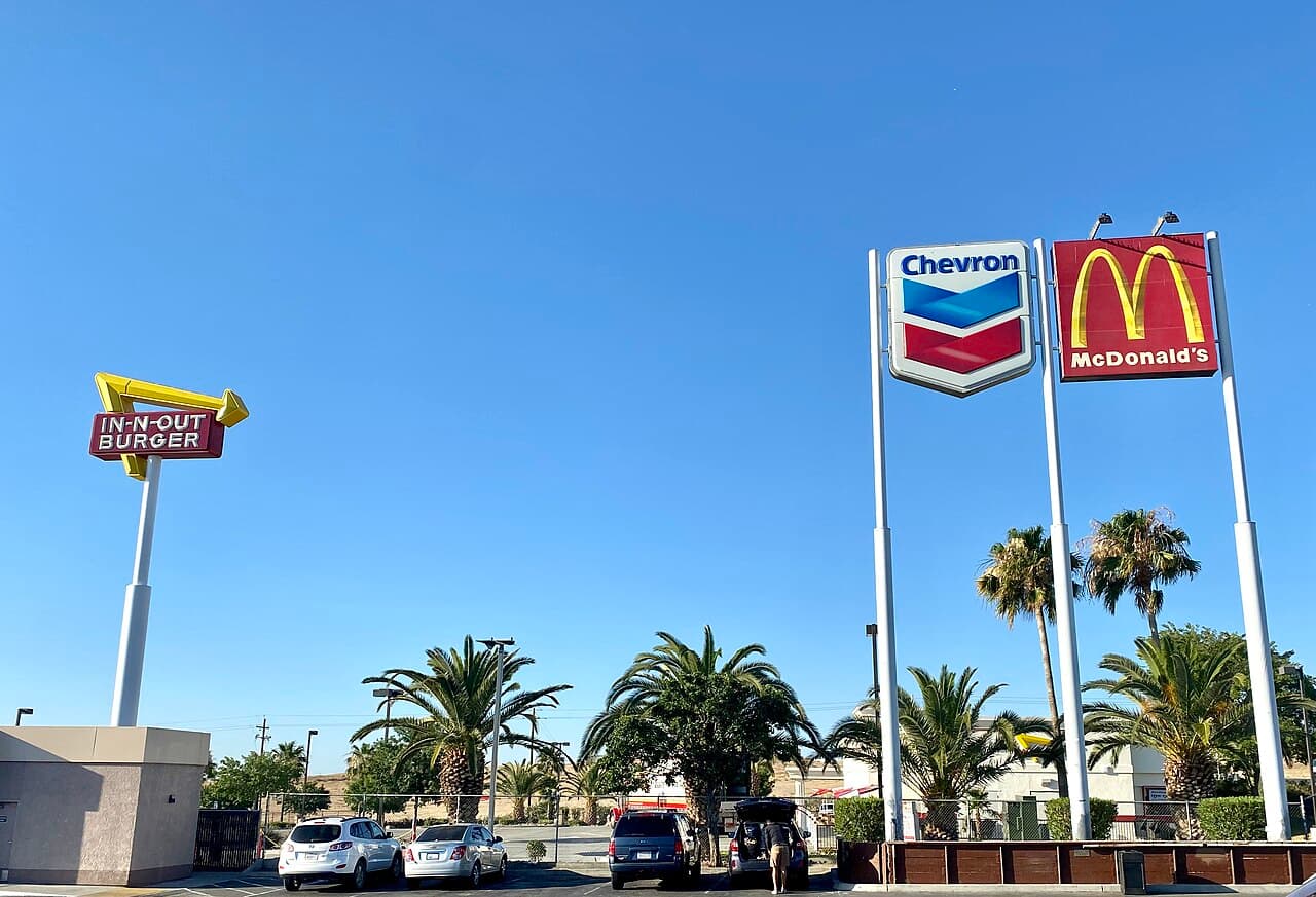 Restaurant and gas-station signs with palm trees near Interstate 5 in Kettleman City.