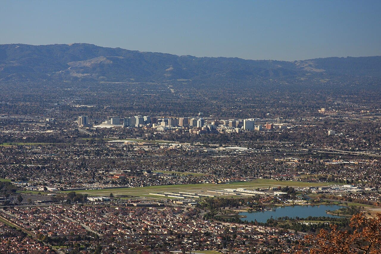 San Jose neighborhoods and downtown skyline with the Santa Cruz Mountains beyond.
