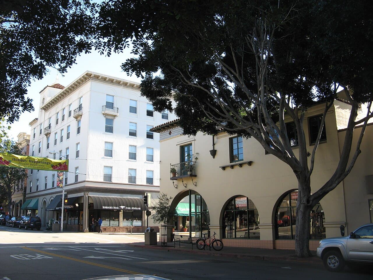 Tree-lined downtown San Luis Obispo street with historic storefronts and arched entrances.